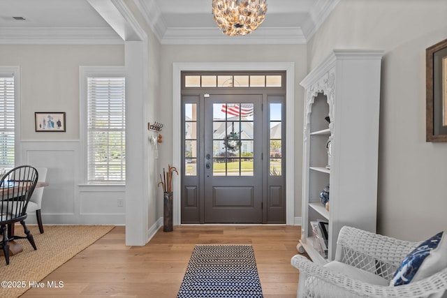 5151 Creswell Dr, Leland, NC 28451 - foyer featuring a chandelier, light wood-style floors, ornamental molding, and wainscoting