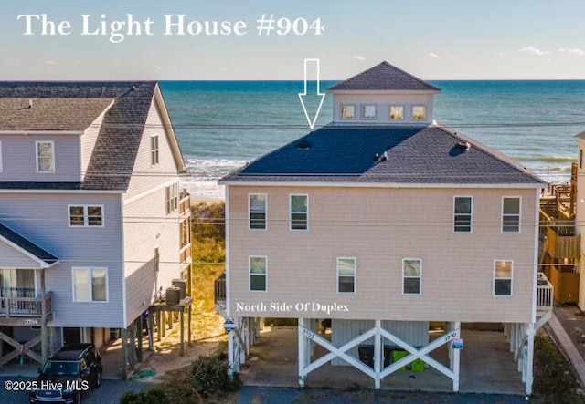 rear view of house featuring central AC unit and a water view