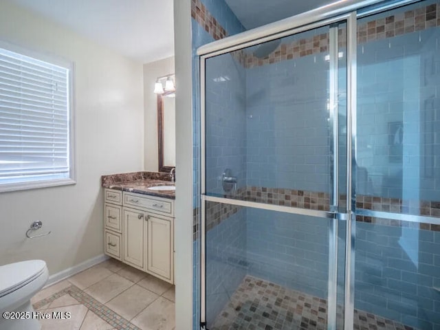 bathroom featuring vanity, tile patterned floors, toilet, and a stall shower