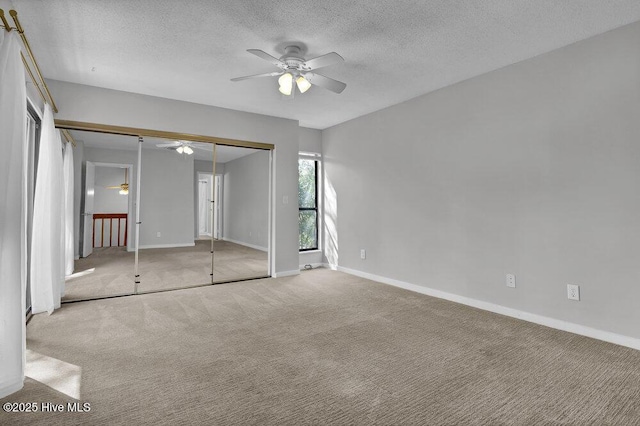 unfurnished bedroom with a textured ceiling, a ceiling fan, baseboards, and carpet floors