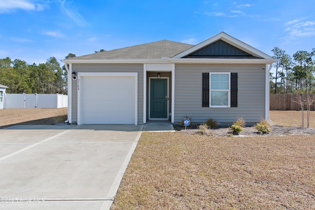 view of front of home featuring an attached garage, board and batten siding, driveway, and fence