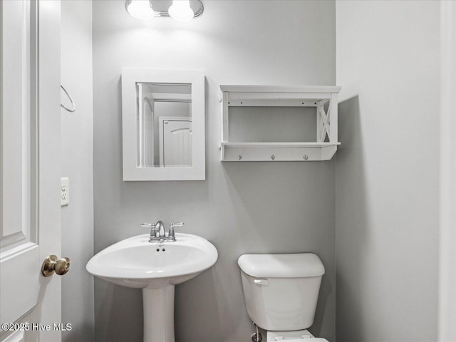 half bath featuring toilet and a sink