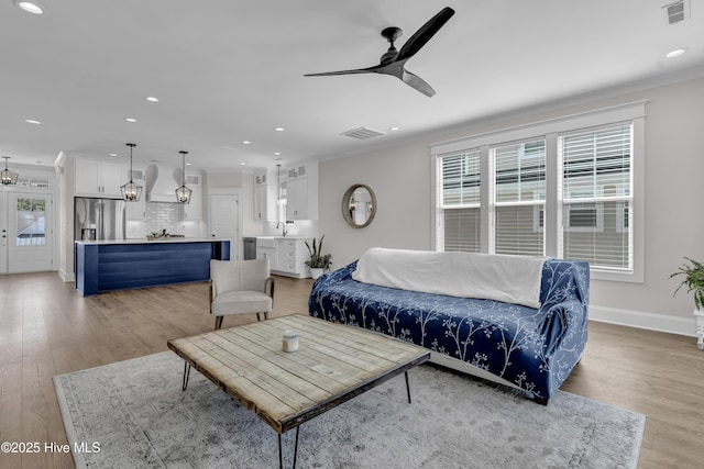 living area featuring visible vents, a healthy amount of sunlight, and ceiling fan