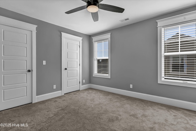 unfurnished bedroom with visible vents, baseboards, a ceiling fan, and carpet flooring