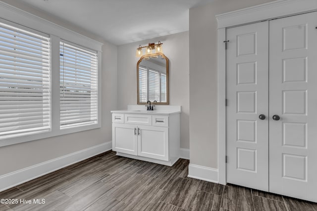 bathroom featuring wood finish floors, baseboards, and vanity