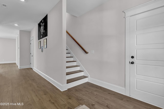 interior space with stairway, recessed lighting, baseboards, and wood finished floors