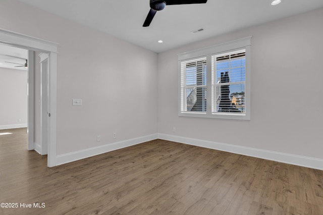 unfurnished room featuring visible vents, baseboards, a ceiling fan, and wood finished floors