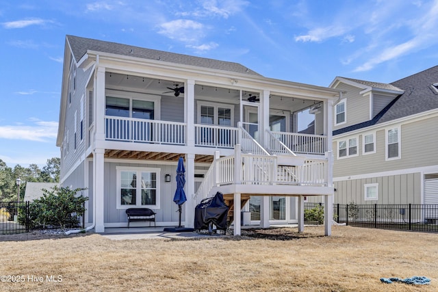 rear view of house with a ceiling fan, fence, a patio area, and board and batten siding