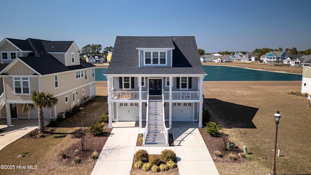 view of front of home with stairway, a shingled roof, concrete driveway, a garage, and a residential view