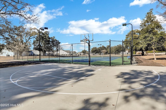 view of basketball court with community basketball court, a gate, fence, and a tennis court