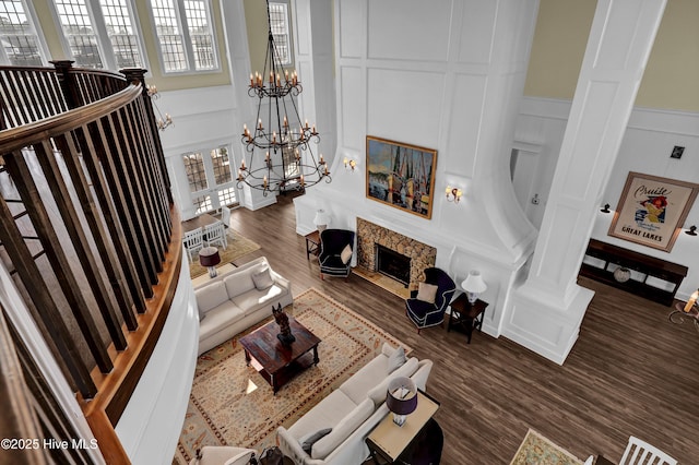 living room with a notable chandelier, a decorative wall, and dark wood-style floors