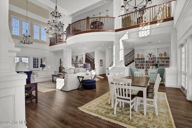 dining room with an inviting chandelier, decorative columns, and wood finished floors