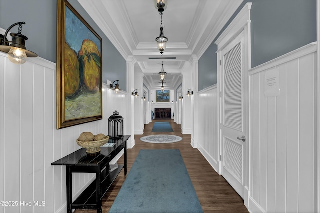 hall featuring a wainscoted wall, ornamental molding, and dark wood-style flooring