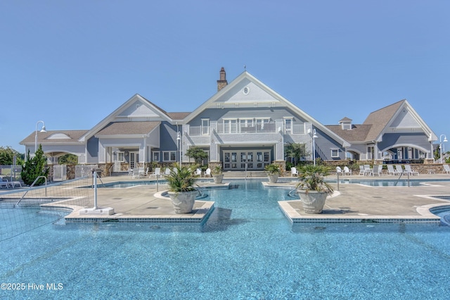 pool with french doors and a patio