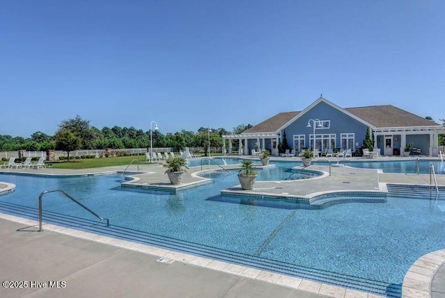 community pool with a patio and fence