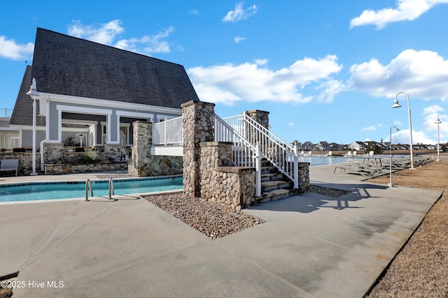 pool featuring stairs and a patio