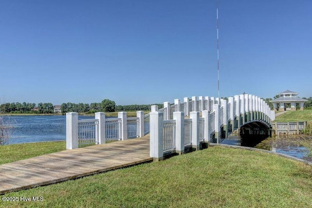 dock area with a yard and a water view