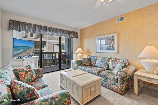 living room with visible vents, carpet, a ceiling fan, and wallpapered walls