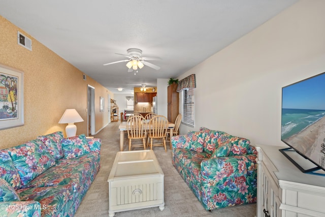 carpeted living room featuring a ceiling fan and visible vents