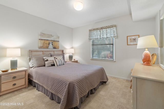 bedroom featuring light colored carpet and baseboards