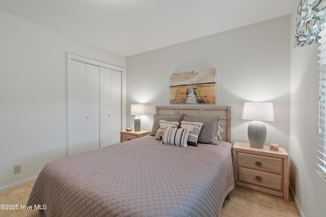 bedroom featuring a closet, light colored carpet, and baseboards