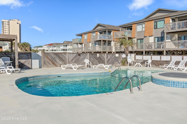 pool with a patio and fence