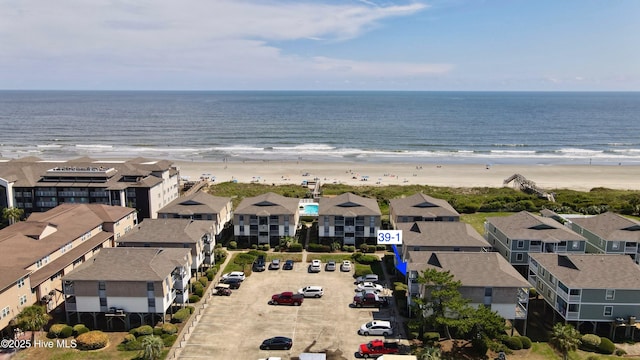 birds eye view of property featuring a beach view and a water view