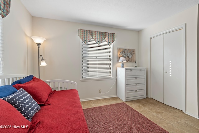 bedroom with light tile patterned floors and a closet