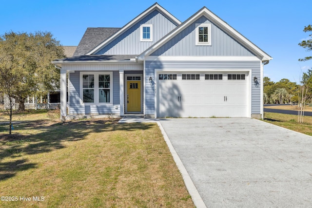 view of front facade featuring a front yard, a garage, driveway, and roof with shingles