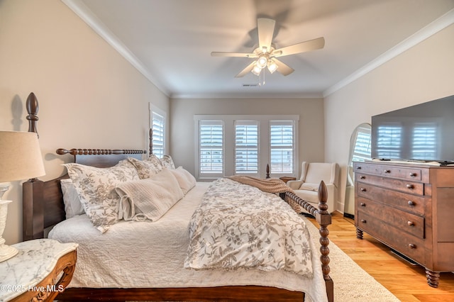 bedroom featuring crown molding, multiple windows, a ceiling fan, and light wood-type flooring