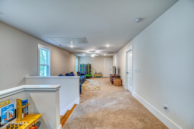 hallway featuring an upstairs landing, baseboards, attic access, and carpet