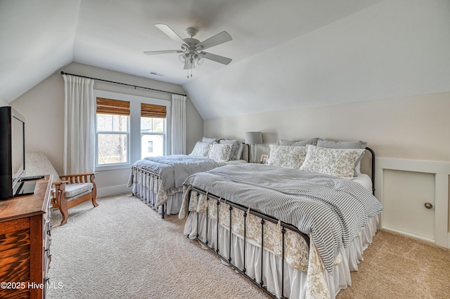 bedroom featuring a ceiling fan, vaulted ceiling, light colored carpet, and visible vents