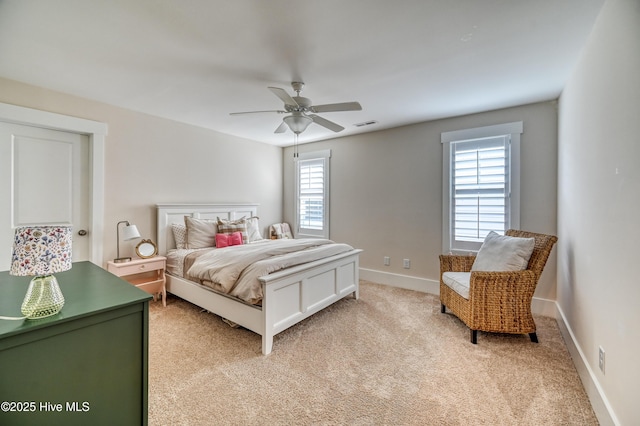 bedroom with light carpet, multiple windows, a ceiling fan, and baseboards