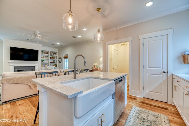 kitchen with dishwasher, crown molding, light wood-style floors, and a sink