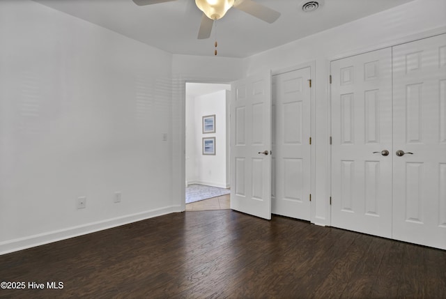 unfurnished bedroom featuring visible vents, ceiling fan, baseboards, and wood finished floors