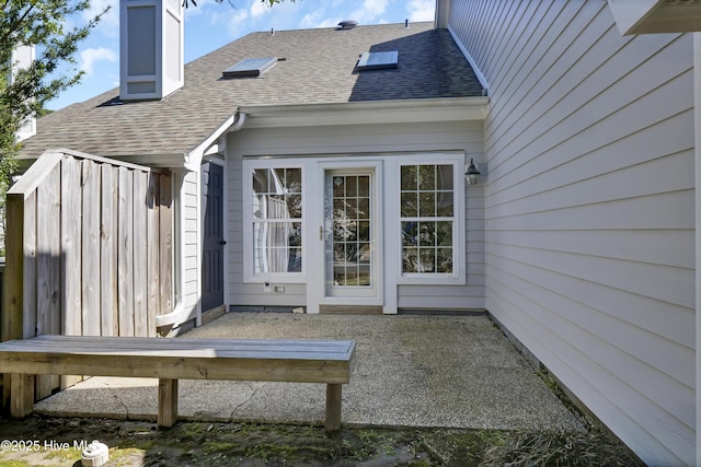 exterior space with a chimney and roof with shingles