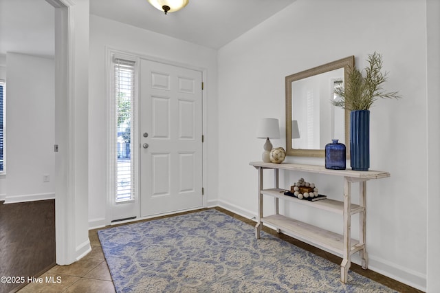 tiled entryway with plenty of natural light and baseboards