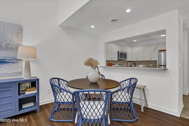 dining space featuring visible vents, recessed lighting, wood finished floors, and baseboards