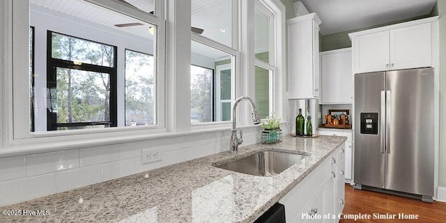 2760 Alvernia Dr, Castle Hayne, NC 28429 - kitchen featuring stainless steel fridge, a sink, white cabinets, and backsplash