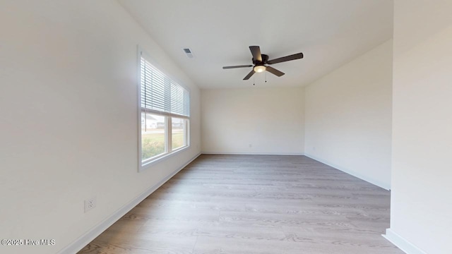 spare room with light wood-style flooring, baseboards, visible vents, and ceiling fan