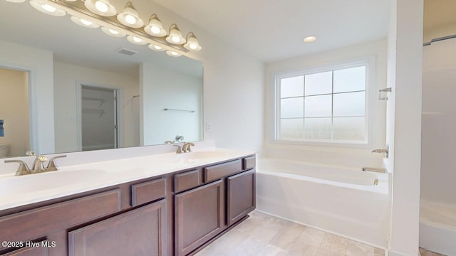 bathroom featuring a sink, visible vents, a bath, and double vanity