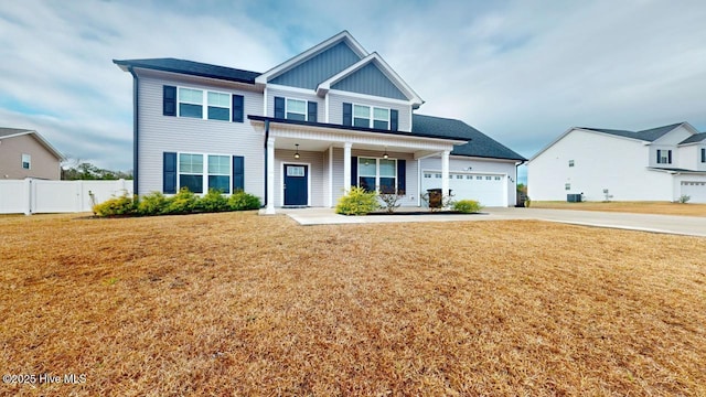 craftsman inspired home featuring fence, driveway, an attached garage, a front lawn, and board and batten siding