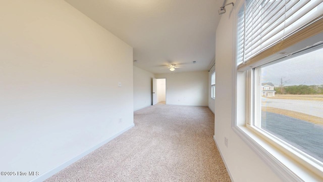 unfurnished room featuring baseboards, carpet floors, and ceiling fan