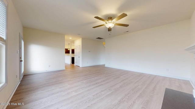 unfurnished room with baseboards, a ceiling fan, visible vents, and light wood-type flooring