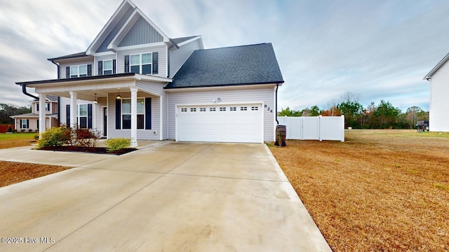 view of front of house featuring board and batten siding, fence, a front yard, a garage, and driveway