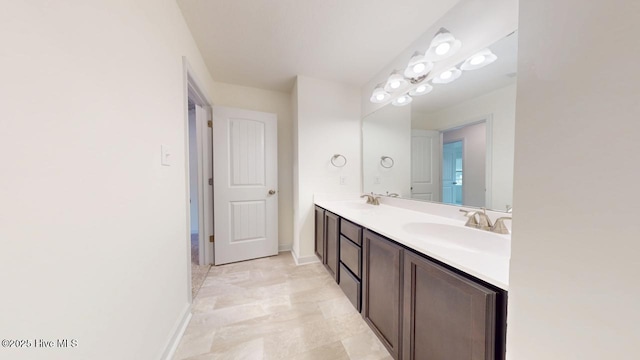 bathroom with a sink, baseboards, and double vanity