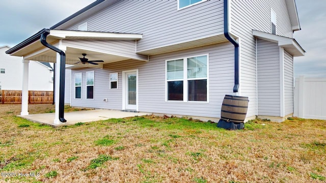 rear view of house with fence, a lawn, a ceiling fan, and a patio area