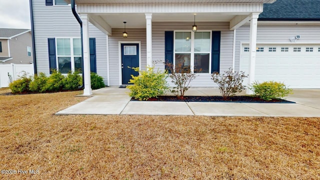 property entrance with an attached garage, driveway, and a yard