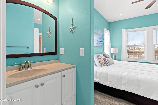 449 E Fourth St, Ocean Isle Beach, NC 28469 - bedroom featuring a sink, wood finished floors, a textured wall, arched walkways, and a ceiling fan