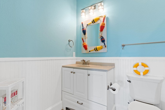 449 E Fourth St, Ocean Isle Beach, NC 28469 - half bath with vanity, a wainscoted wall, and toilet